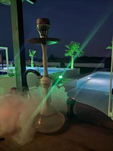 a table with a fountain in front of a pool at night at Villa Roza 2 in Kallithea Halkidikis