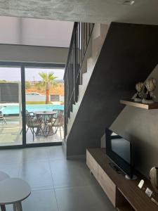 a living room with a tv and a pool at Villa Roza 2 in Kallithea Halkidikis