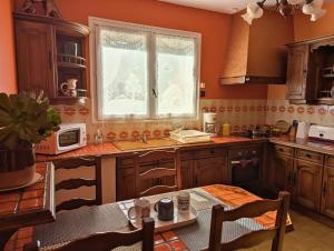 a kitchen with wooden cabinets and a table and a window at Gite De La Meronne in Vindelle