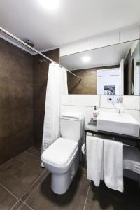 La salle de bains est pourvue de toilettes blanches et d'un lavabo. dans l'établissement Hotel Alto San Isidro, à San Isidro
