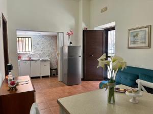 a kitchen with a refrigerator and a table with flowers at HeraDea in Crotone