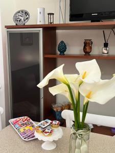 a table with a vase with flowers on it at HeraDea in Crotone