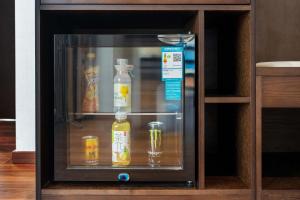 a glass cabinet with bottles and jars of alcohol at Aofeng Tangquan Secluded Villa in Jianchuan +45 photos
