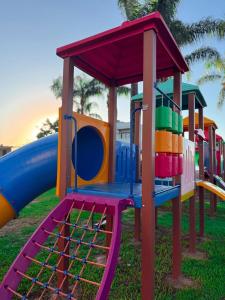 a playground with a slide in the grass at Hotel São Luiz in São Gabriel