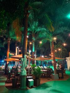 a resort with a statue and tables and palm trees at night at Hotel São Luiz in São Gabriel