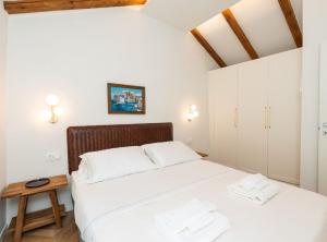 a bedroom with a large bed with white sheets at Villa Jele in Dubrovnik
