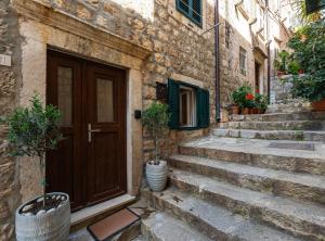 an old stone building with a wooden door and stairs at Villa Jele in Dubrovnik