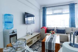 a living room with a couch and a table at Pearl Homes Nanyuki in Nanyuki