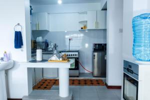a kitchen with a white table and a stove at Pearl Homes Nanyuki in Nanyuki