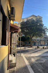 a building on the side of a street with a tree at HeraDea in Crotone