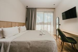 a bedroom with a bed and a desk and a television at La Mirage Hotel in Tsilivi