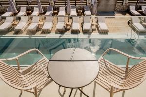 a table and chairs in front of a pool at La Mirage Hotel in Tsilivi +2 photos