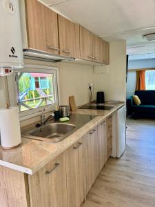 a kitchen with wooden cabinets and a sink and a window at Domek z widokiem na las in Nielisz