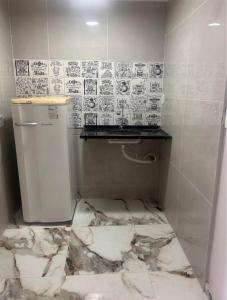 a bathroom with a marble floor and a refrigerator at Suítes em Cabo Frio in Cabo Frio +40 photos
