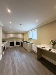 a large kitchen with wooden floors and white cabinets at 4 James street in Selby +7 photos