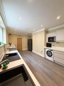 a large kitchen with white cabinets and a sink at 4 James street in Selby