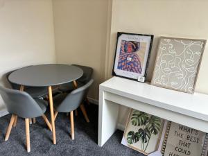 a table and two chairs next to a table with a picture at Cute Central House Sleeps 4 in Stafford