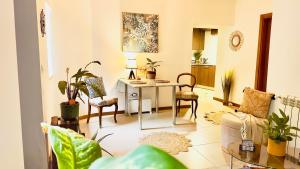 a living room with a table and some plants at Wylde Roots River House - with natural river swimming pools in Couto de Baixo