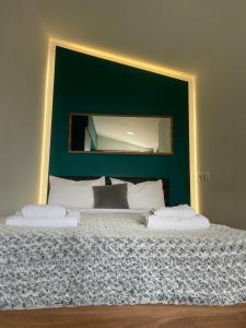 a bedroom with a large bed with a green wall at Luna's Sea View & City Center Apartment in Alexandroupoli