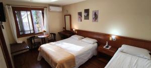 a hotel room with two beds and a window at Estalagem Vila Suzana - Quadra de Beach Tennis Indoor in Canela