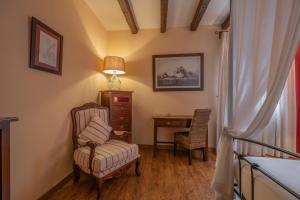 a room with a chair and a desk and a lamp at Casona De Torres in Mondéjar +84 photos