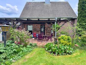 a cottage with a patio with a table and chairs at Xantenglück in Xanten