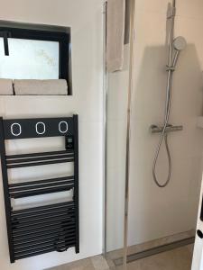 a bathroom with a shower and a towel rack at Cocon proche de Lyon in Neyron +24 photos