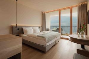 a hotel room with a bed and a large window at Niedermair Nature Retreat in Parcines +54 photos