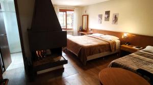 a hotel room with a fireplace and a bed at Estalagem Vila Suzana - Quadra de Beach Tennis Indoor in Canela