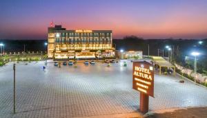 a hotel with a large parking lot at night at Hotel Altura CHHATRAL in Nandāsan