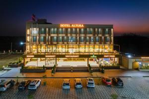 a hotel with cars parked in front of it at night at Hotel Altura CHHATRAL in Nandāsan
