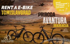 two bikes parked in a field with a poster at Honey Glamping Resort with jacuzzi in Tomislavgrad