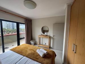 a bedroom with a bed and a mirror and a window at Manhattan Escape Suite By Ezey Tours in Cape Town