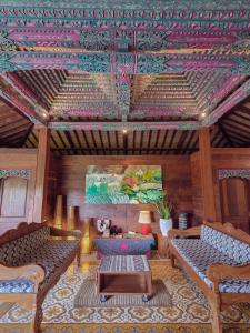 a living room with two couches and a ceiling at Villa Asrava Ubud in Ubud