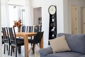 a dining room with a table and a clock on a wall at Jacarandas Islantilla in Islantilla