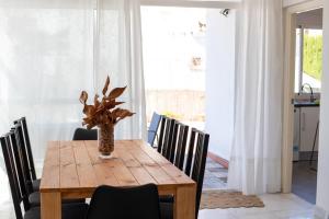 a dining room table with chairs and a vase with a plant at Jacarandas Islantilla in Islantilla +35 photos