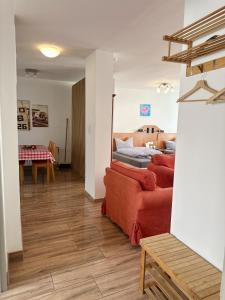 a living room with a red couch and a table at Pension Scheffler in Potsdam