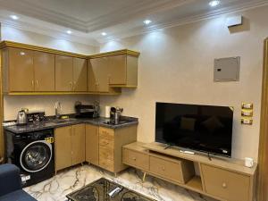 a kitchen with a sink and a tv in a room at Fatah O 9 in Luxor