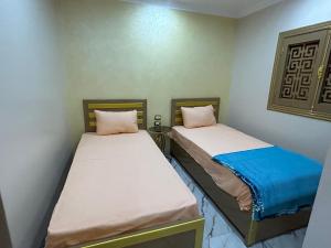 two beds in a small room withermottermottermottermott at Fatah O 9 in Luxor