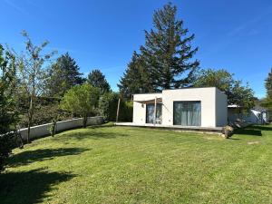 a small white house with a large yard at Cocon proche de Lyon in Neyron