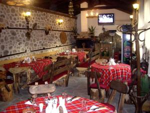a restaurant with tables and chairs and a tv at Popsokol House in Bratsigovo
