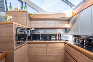 a kitchen with wooden cabinets and a skylight at 2BR Heated Yacht, Lymington Centre, Beautiful View in Lymington