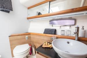 a bathroom with a sink and a toilet and a mirror at 2BR Heated Yacht, Lymington Centre, Beautiful View in Lymington +19 photos
