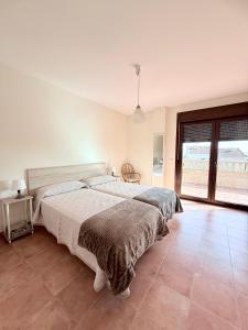 a bedroom with a large bed and a large window at CASA DE AREAS in Sanxenxo
