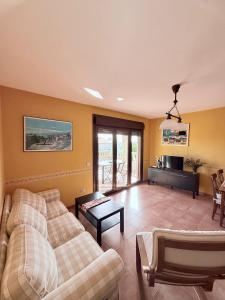 a living room with two couches and a tv at CASA DE AREAS in Sanxenxo