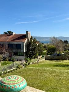 a green yard with a house in the background at CASA DE AREAS in Sanxenxo