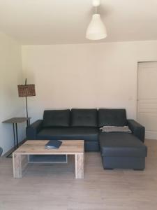 a living room with a black couch and a coffee table at Gîte d'étape Chez Isa in Vers