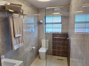 a bathroom with a toilet and a glass shower at Lovista in Tygerberg Hills +11 photos
