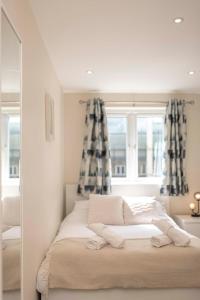 a bedroom with a bed with curtains and a mirror at The Burleigh palace in Cambridge