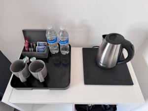 a table with a coffee pot and water bottles on it at The Villas in Rock Ferry +26 photos